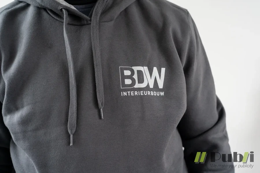 Detail van een zwarte hoodie met wit BDW Interieurbouw-logo op de borst